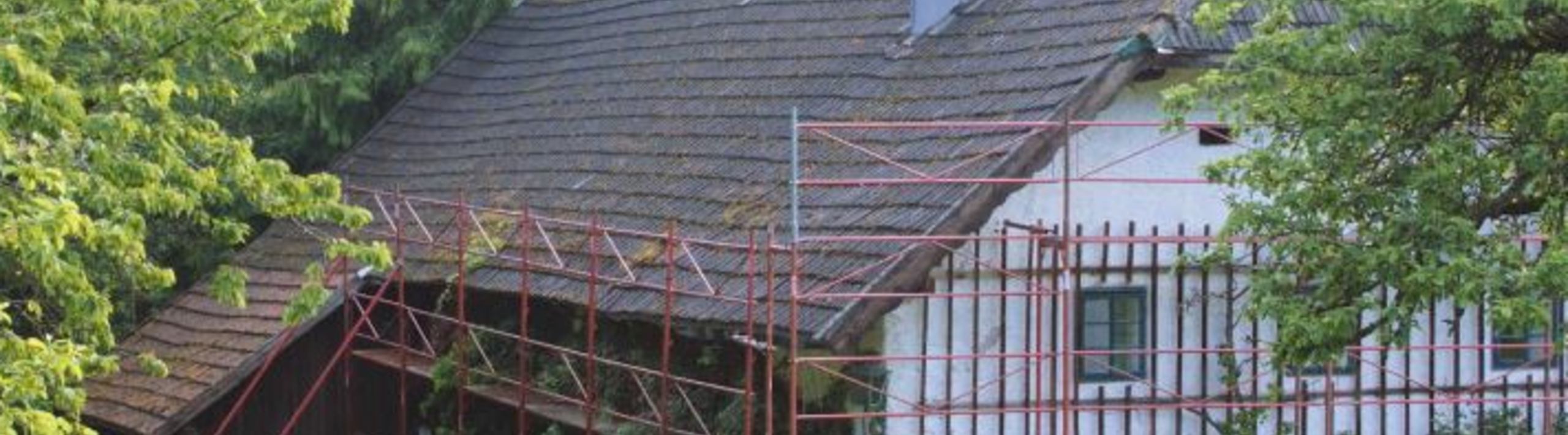 Stugans gamla tak före takrenoveringen (med byggställning) med PREFA-takshingel.