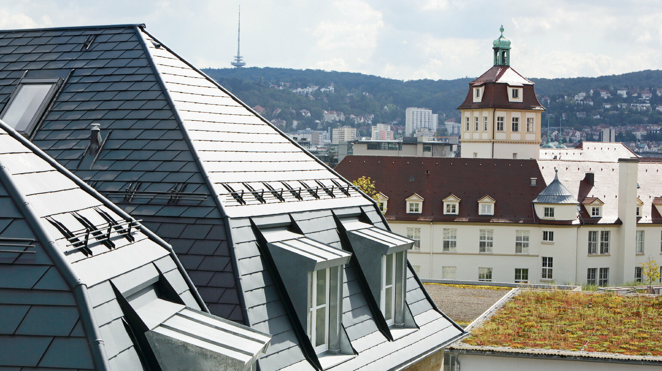 Gammalt rådhus i Stuttgart med brutet tak och många takkupor med fönster, beklätt med aluminumshingel från PREFA i P.10 antracit