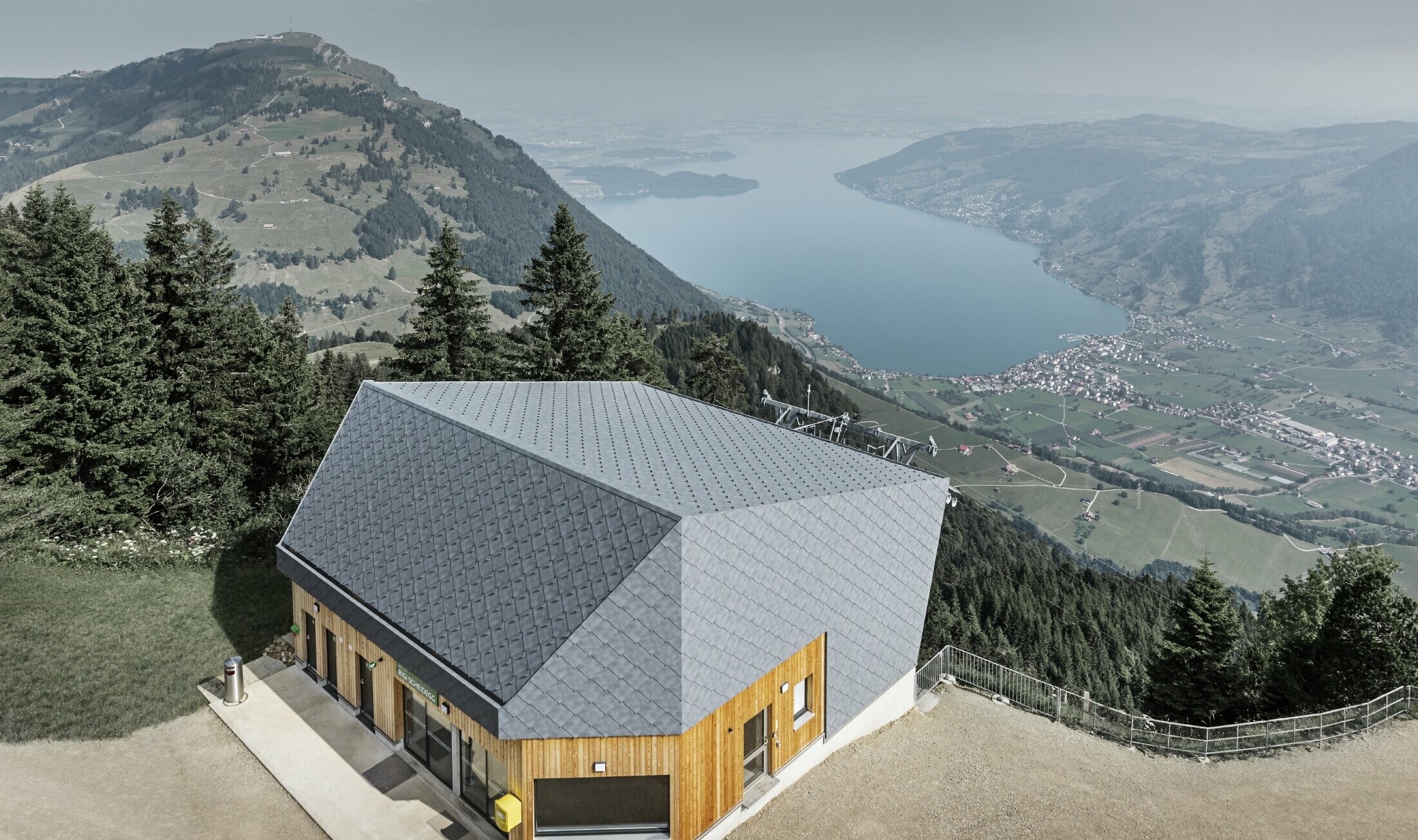 Flygfoto över linbanan vid bergstationen i Rigi Scheidegg, belagd med PREFA väggromber 44 × 44 i P.10, stengrått och trä.