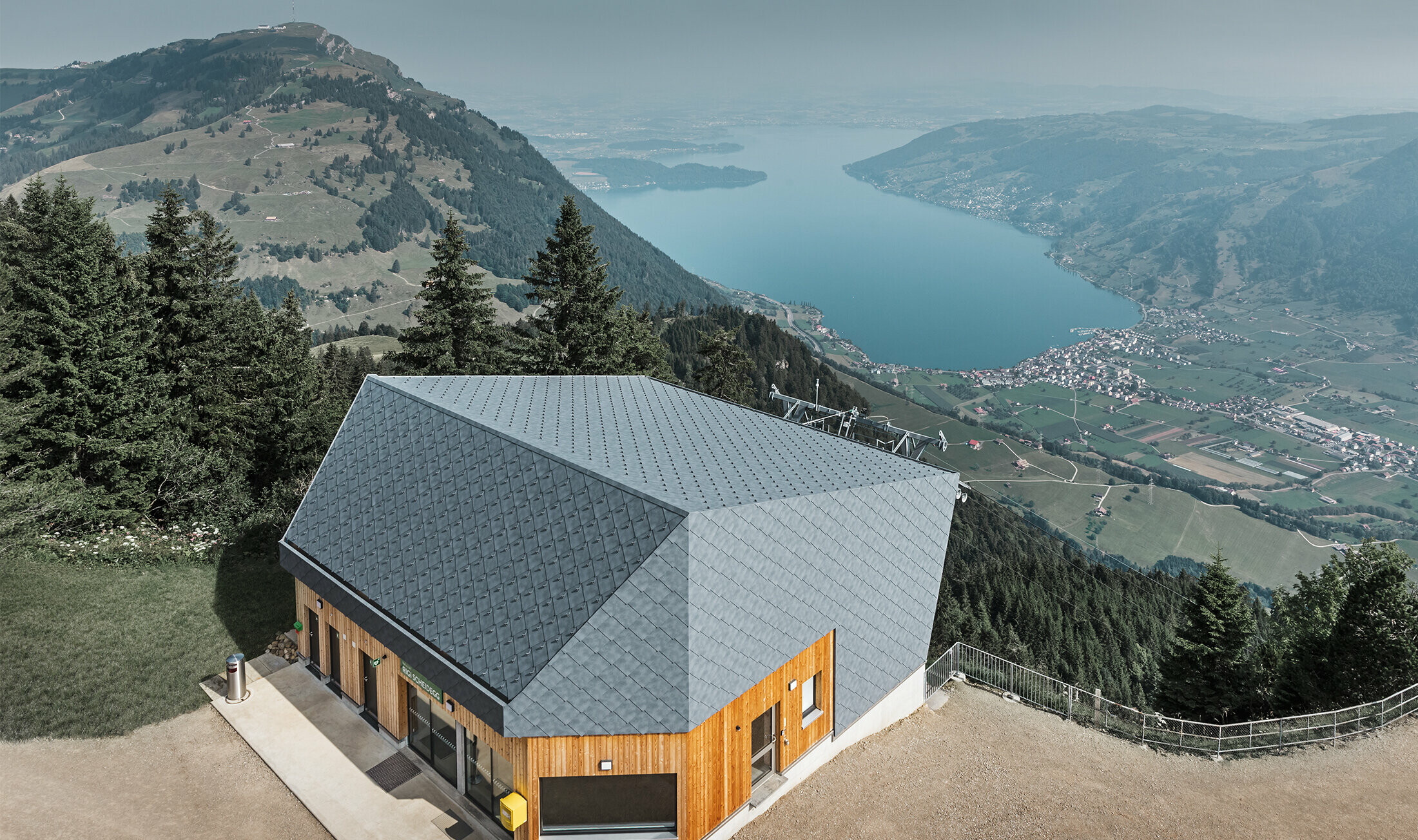 Flygfoto över linbanan vid bergstationen i Rigi Scheidegg, belagd med PREFA väggromber 44 × 44 i P.10, stengrått och trä.