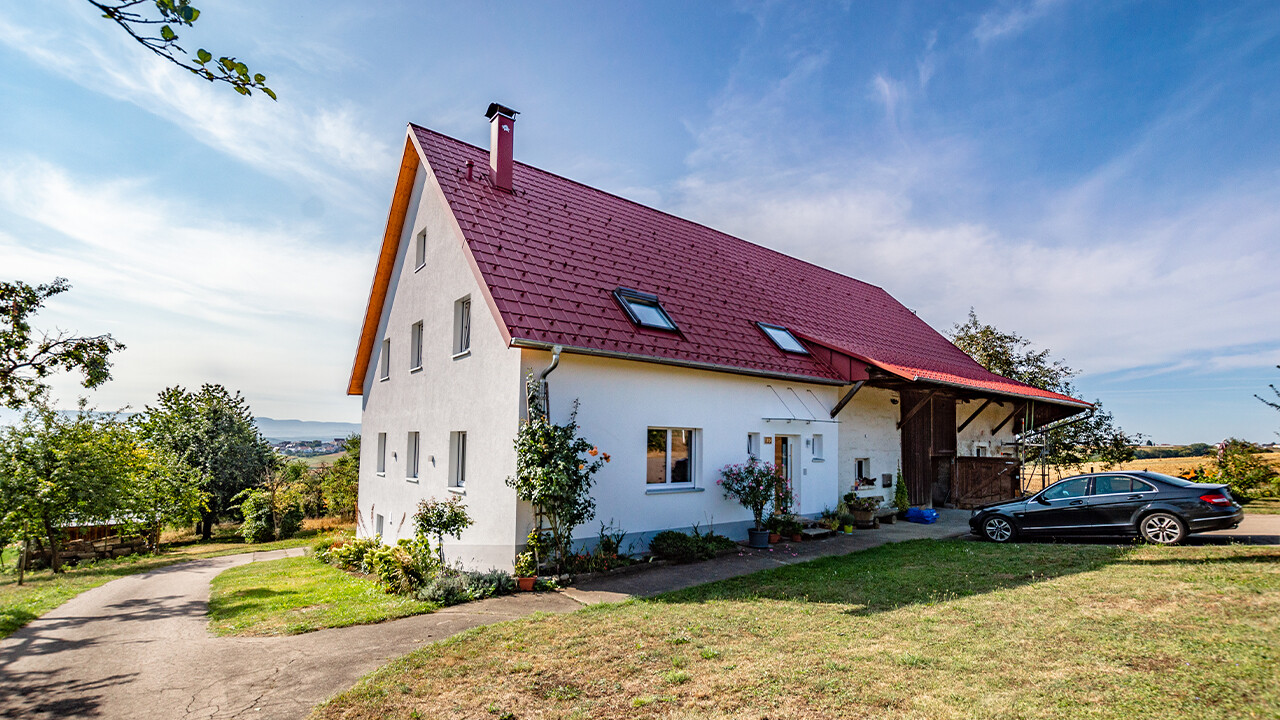 Gammal liten gård på landet, vackert renoverad med PREFA takplattor i oxidrött.