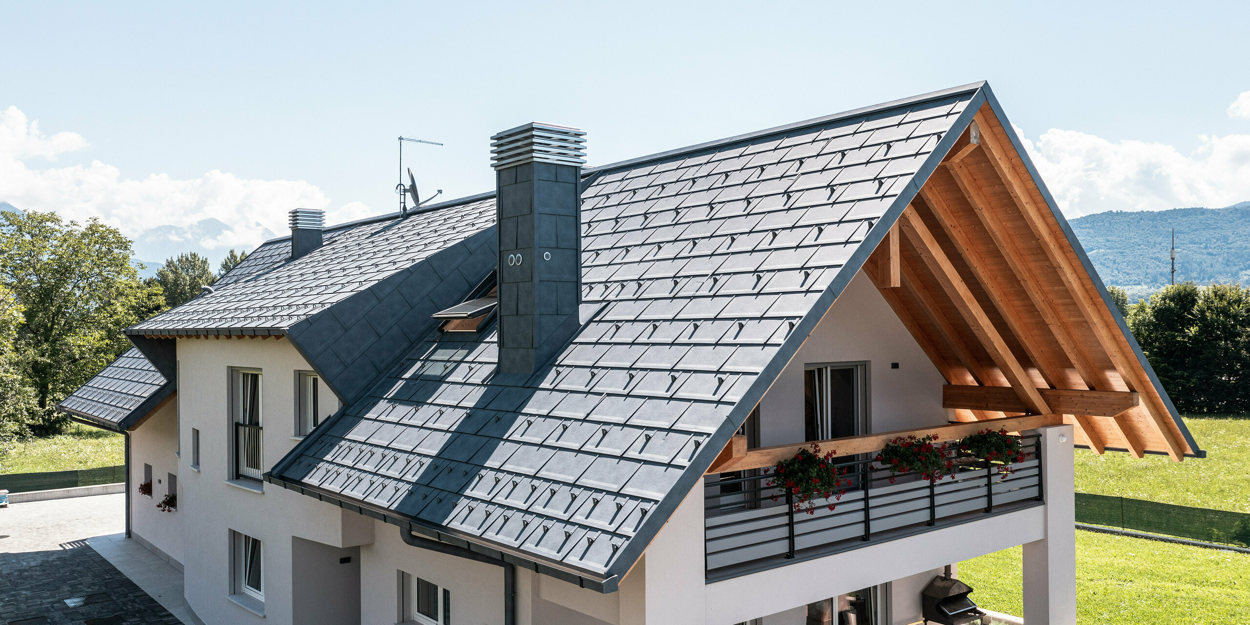 Dieses malerische Einfamilienhaus in Bellun ist mit PREFA R.16 Dachplatten in P.10 Anthrazit eingedeckt, die sowohl Stil als auch Funktionalität bieten. Die Kombination aus einem modernen Aluminiumdach und traditionellen Holzelementen unter dem Dach ergibt ein ansprechendes Gesamtbild, das sich perfekt in die natürliche Umgebung und die Bergkulisse Italiens einfügt.