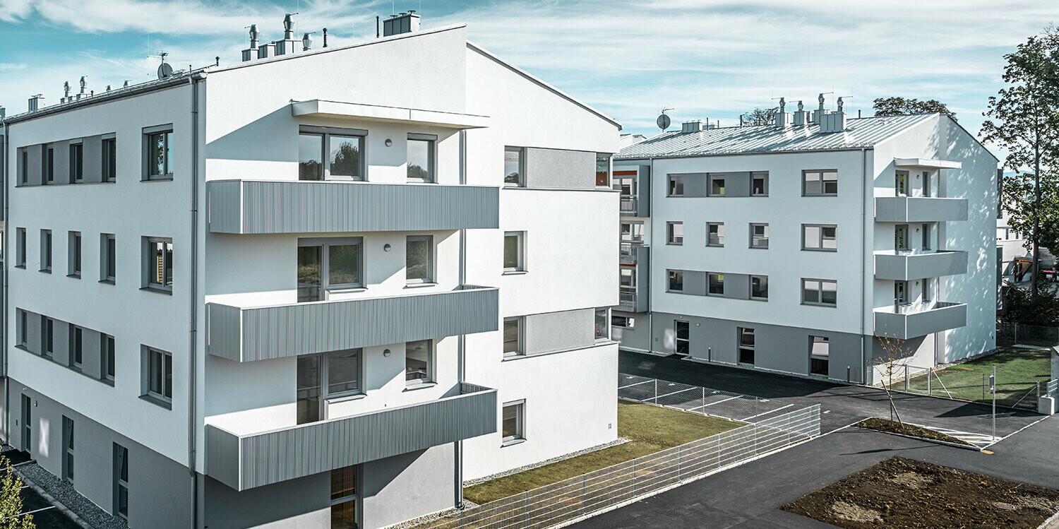 Modernt bostadshus med vit fasad och balkonger med PREFA sicksackprofil i silvermetallic