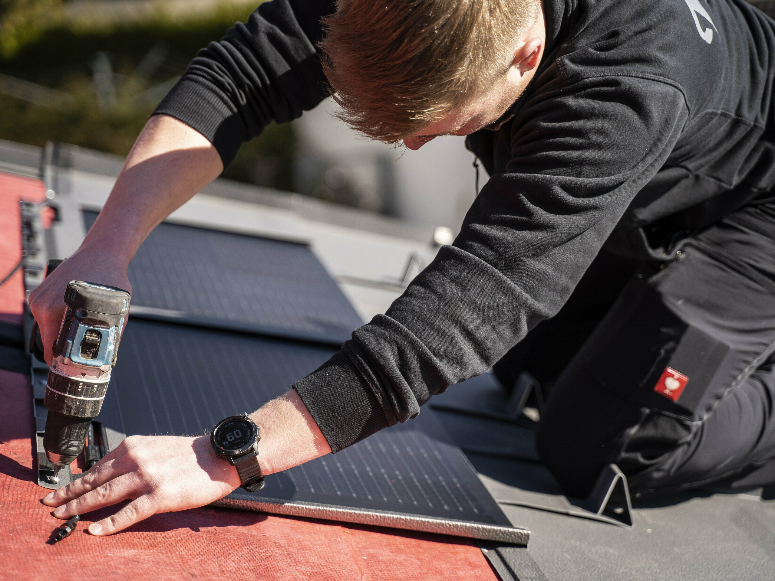 En PREFA-medarbetare vid monteringen av solar takplatten.